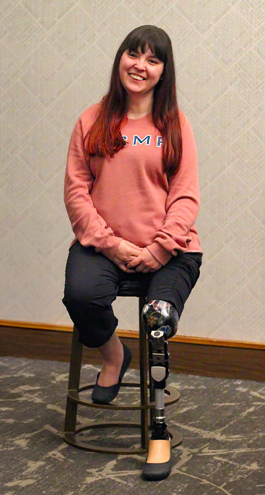 Une femme amputée d’une jambe est assise sur un tabouret dans un hôtel.