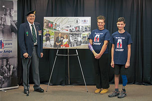 War Amps member Charlie Jefferson and members of The War Amps Child Amputee (CHAMP) Program, Olivia Miller and Dante Fotia, unveil the commemorative envelope.