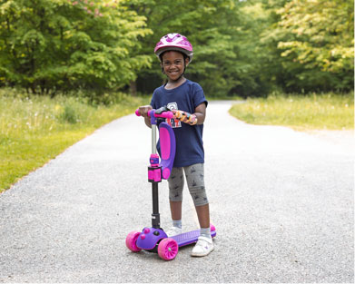 Trixie, une petite fille, fait de la trottinette à l’aide de son bras artificiel.